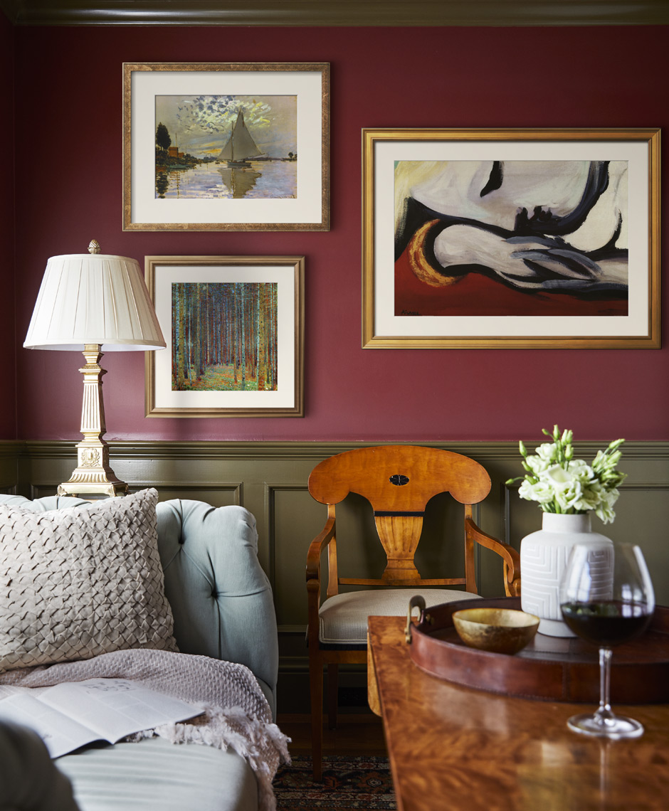Red painted walls with framed art in cozy room with sofa and coffee table Sean Dagen Photography