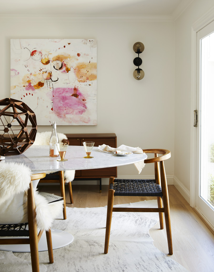 Modern dining room table and chairs with painting and modern sculpture and cow hide rug  Sean Dagen Photography