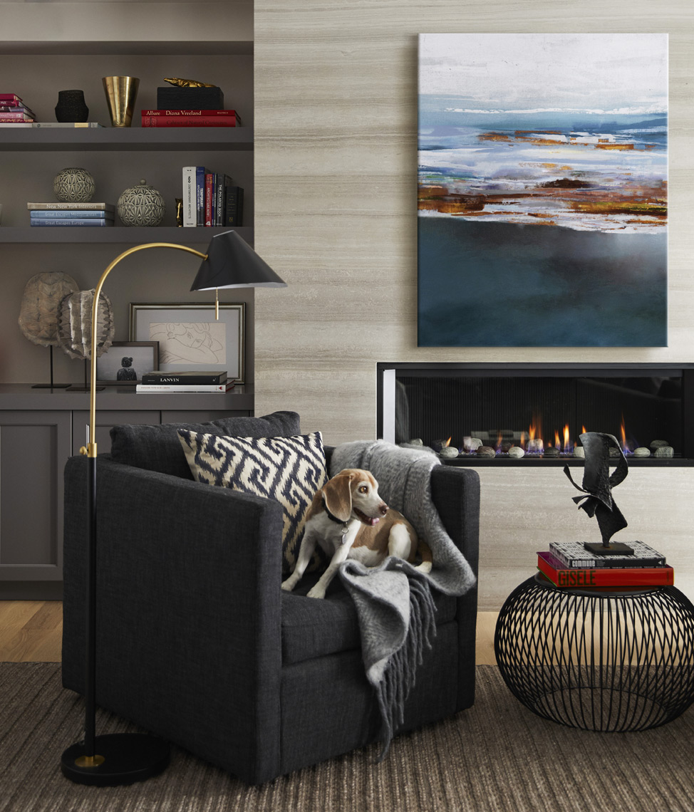 Dog on leather chair in front of modern fireplace with painting on mantle Sean Dagen Photography