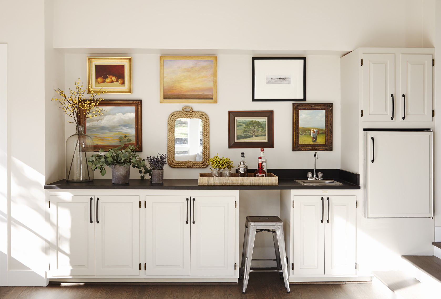 Bar with wall of framed art paintings and photographs in contemporary home Sean Dagen Photography