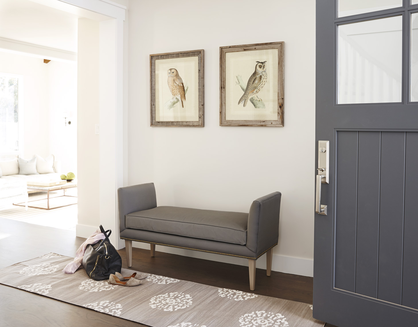 Entry way foyer with bench and framed art prints on wall