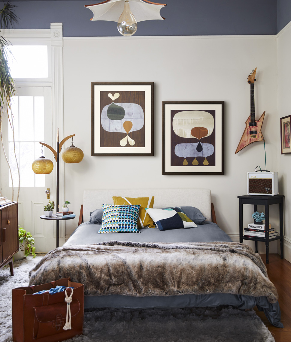 Bedroom with bed framed art on wall hangin guitar and vintage lamp Sean Dagen Photography