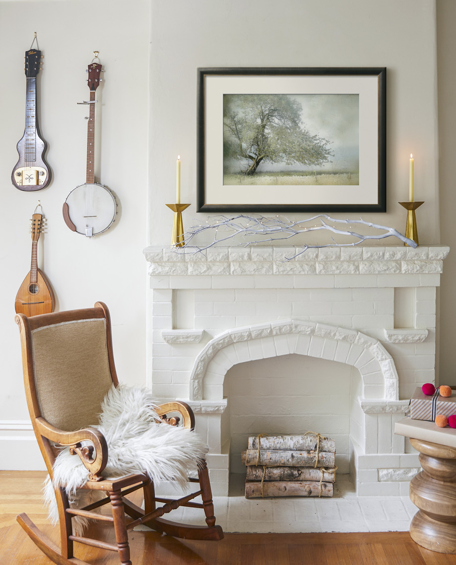 White fireplace with instruments hung on wall  framed art and chair Sean Dagen Photography